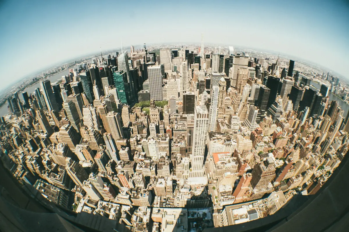 Fisheye photo of a city skyline, the horizon bends into an arc and the buildings lean toward the center